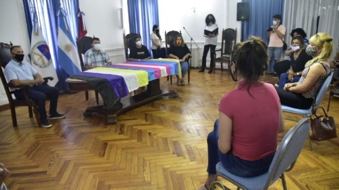 Firma de contratos a personas trans y la bandera de la Diversidad que y flamea permanentemente