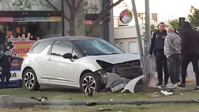 Un auto chocó con una moto e impactó contra un poste de luz del cantero
