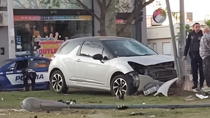 Un auto chocó con una moto e impactó contra un poste de luz del cantero
