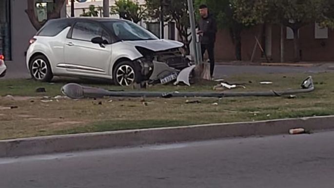 Un auto chocó con una moto e impactó contra un poste de luz del cantero