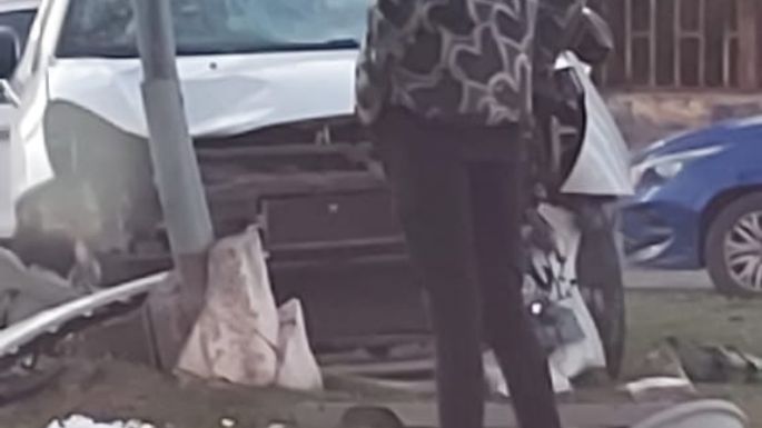 Un auto chocó con una moto e impactó contra un poste de luz del cantero