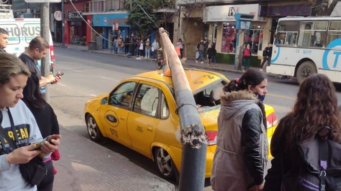 Se cayó un poste arriba de un taxi