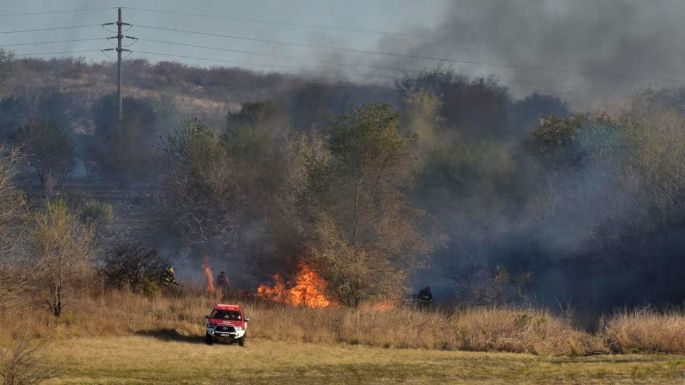 Bomberos combaten un incendio forestal entre la ciudad de Córdoba y La Calera