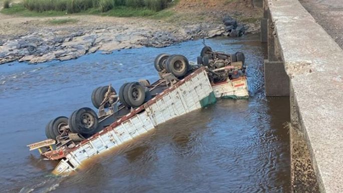 Volcó en un puente y cayó con el camión al río